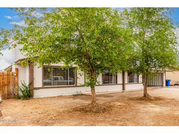 Charming single-story home featuring desert landscaping, brick accents, and mature trees at 3042 N 87Th Ave, Phoenix, AZ 85037