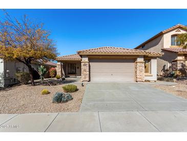 Charming single-story home featuring a tile roof, stone accents, desert landscaping, and a two-car garage at 3650 W Denali Dr, Anthem, AZ 85086