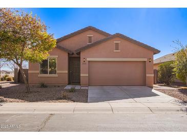 Charming single-story home featuring a two-car garage, desert landscaping, and neutral color palette at 41375 W Barcelona Dr, Maricopa, AZ 85138