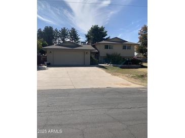 Charming home featuring a spacious driveway and a well-manicured front yard under a beautiful blue sky at 4327 W Waltann Ln, Glendale, AZ 85306