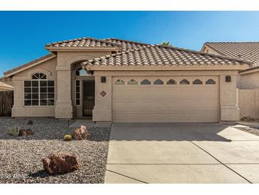 Charming single-story home featuring a well-manicured desert landscape, neutral stucco exterior, and a tile roof at 635 W Douglas Ave, Gilbert, AZ 85233