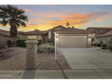 Inviting home featuring a tile roof, desert landscaping, and a two car garage under a colorful sunset at 9513 E Hercules Dr, Sun Lakes, AZ 85248