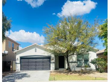 Charming single-story home featuring a well-maintained front yard and a two-car garage at 10030 W Illini St, Tolleson, AZ 85353