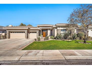 Charming single-story home with stone accents, a three-car garage, and manicured landscaping at 1738 W Yosemite Pl, Chandler, AZ 85248