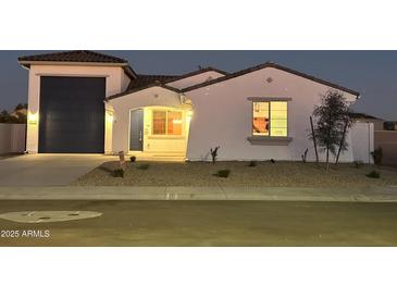 Inviting single-Gathering home featuring a well-manicured front yard and an attached two-car garage in a suburban neighborhood at 18743 N Avelino Dr, Maricopa, AZ 85138