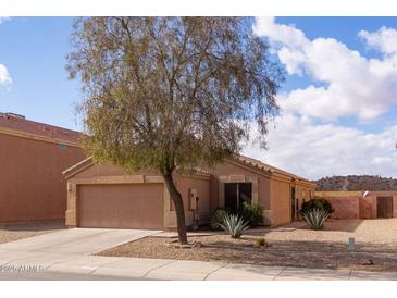 Charming single-story home featuring a well-maintained front yard with desert landscaping and a two-car garage at 24816 N Good Pasture Ln, Florence, AZ 85132