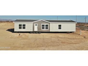 A manufactured home with gray and white siding and a gravel surround at 2735 S 357Th Dr, Tonopah, AZ 85354