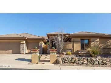 Charming single-story home featuring a desert landscape, a stone facade, and a two-car garage at 42043 N Bradon Way, Phoenix, AZ 85086