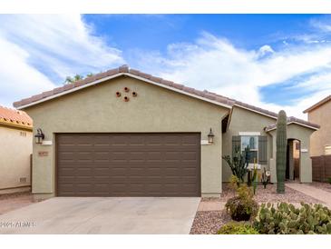 Charming single-story home featuring a brown two-car garage and desert landscaping at 42577 W Rosalia Dr, Maricopa, AZ 85138