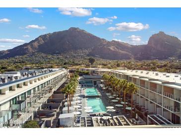 Resort-style living with a pool, palm trees, and mountain views under a bright, sunny sky at 5455 E Lincoln Dr # 2009, Paradise Valley, AZ 85253