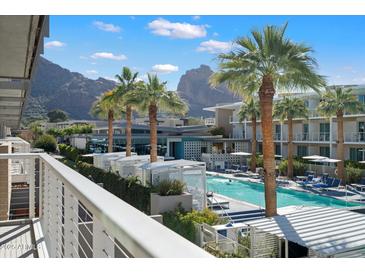 Resort style swimming pool with palm trees and view of mountains from balcony at 5455 E Lincoln Dr # 2009, Paradise Valley, AZ 85253