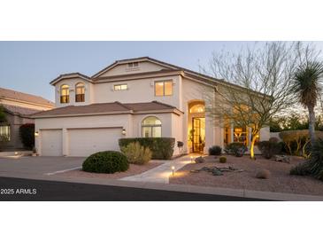 Inviting two-story home boasts a three-car garage, desert landscaping, and a warm, welcoming facade at 7357 E Rochelle Cir, Mesa, AZ 85207