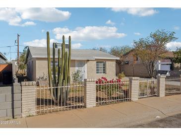 Charming single-story home with a desert-friendly landscaped front yard enclosed by a decorative wrought iron fence at 9156 W Garfield St, Tolleson, AZ 85353