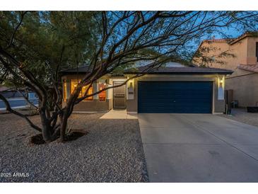 Charming single-story home featuring a desert landscape, a two-car garage, and a well-maintained front yard at 10594 E Wallflower Ln, Florence, AZ 85132