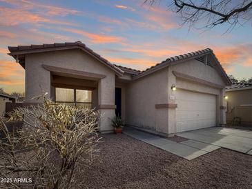 Charming single-story home featuring a two-car garage and low maintenance desert landscaping at 12017 N 151St Dr, Surprise, AZ 85379