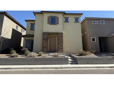 Two-story home featuring a stucco facade, stone accents, and minimal landscaping at 1743 W Pollack St, Phoenix, AZ 85041