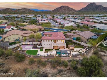 Expansive aerial view of a home with a basketball court, turf lawn, pool, pergola, and mountain views at 28826 N 67Th Dr, Peoria, AZ 85383