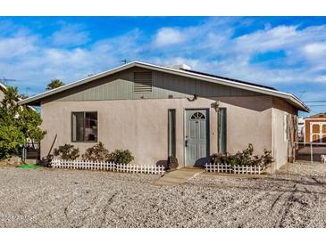 Charming single-story home showcasing a gravel front yard, cozy front porch and neutral color palette at 330 W Northern Ave, Coolidge, AZ 85128