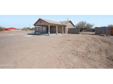 The property features a spacious dirt front yard, covered parking, and block fencing, offering privacy and functionality at 3545 N Hohokam Dr, Eloy, AZ 85131