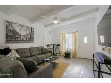 Inviting living room with neutral color palette, ceiling fan, and unique black and white art piece at 4754 N 14Th St, Phoenix, AZ 85014