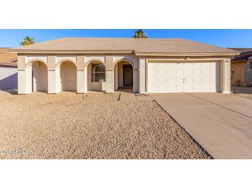 Charming single-story home featuring a two-car garage, low maintenance yard, and covered front entry with arched features at 6132 E Casper St, Mesa, AZ 85205