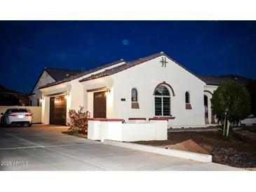 Charming single-story home featuring a well-maintained lawn, two-car garage, and attractive architectural details at 9405 S 47Th Ave, Laveen, AZ 85339