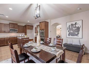 Formal dining room showcasing dark wood table and decor with views into the kitchen at 9556 W Frank Ave, Peoria, AZ 85382