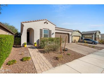 Charming single-story home with a desert landscape, brick walkway, and two-car garage at 19856 W Monterosa St, Litchfield Park, AZ 85340