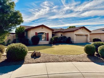 Charming home boasts a well-manicured lawn, desert landscaping, and a two-car garage at 20865 E Shetland St, Queen Creek, AZ 85142