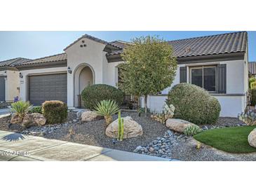 Charming home featuring desert landscaping, including rocks and cacti, plus a gray garage door at 25925 W Mcrae Dr, Buckeye, AZ 85396