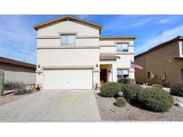 Two-story home featuring a front yard with desert landscaping and an attached two-car garage at 5608 E Lush Vista Vw, Florence, AZ 85132