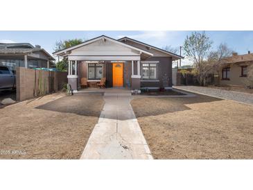 Charming bungalow with an eye-catching orange front door and inviting front porch at 1305 E Brill St, Phoenix, AZ 85006