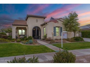 Charming stucco home featuring manicured lawn, beautiful landscaping, and decorative wrought iron accents at 20618 W Western Dr, Buckeye, AZ 85396