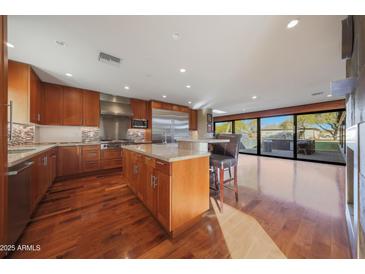 Open-concept kitchen with granite countertops, stainless steel appliances, and a spacious island with breakfast bar seating at 2718 E Campo Bello Dr, Phoenix, AZ 85032