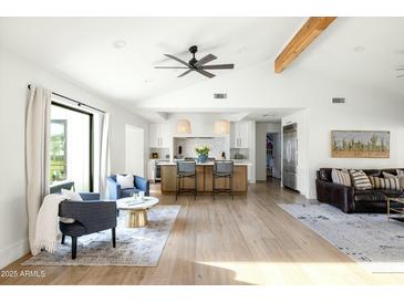 Airy living room featuring stylish furnishings, wood floors, and views of the modern kitchen and outdoors at 3640 E Fairmount Ave, Phoenix, AZ 85018