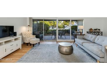 Bright living room featuring stylish furniture and sliding glass doors to the outdoor patio at 5150 N 20Th St # 111, Phoenix, AZ 85016