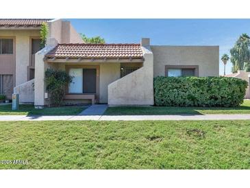 Charming home with desert landscaping, covered porch, and a red tile roof at 5458 W El Caminito Dr, Glendale, AZ 85302