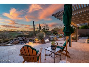 Outdoor patio seating featuring a serene desert landscape with a pergola and colorful sunset skies at 41908 N La Cantera Dr, Anthem, AZ 85086