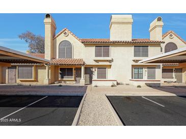 Inviting two-story townhome with a charming facade, red tile roof, and covered parking at 5704 E Aire Libre Ave # 1217, Scottsdale, AZ 85254