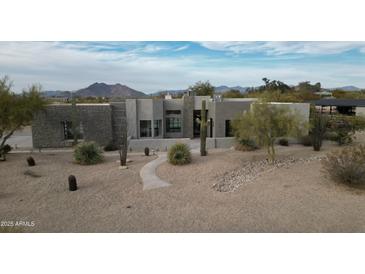 Beautiful modern home with desert landscaping, a stone accent wall, and mountain views at 7070 E Lowden Dr, Scottsdale, AZ 85266