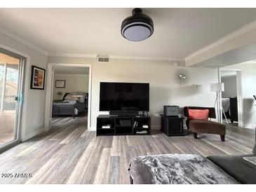 Open living room features a ceiling fan, hardwood floors, and comfortable seating at 8260 E Arabian Trl # 257, Scottsdale, AZ 85258