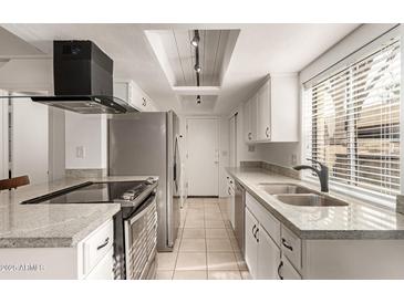 Bright kitchen featuring granite countertops, stainless steel appliances, and modern fixtures at 8841 S 48Th St # 1, Phoenix, AZ 85044