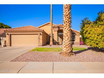 Charming single-story home with a two car garage, desert landscaping, and tile roof at 9230 W Grovers Ave, Peoria, AZ 85382