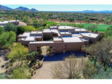 Stunning aerial view of a custom home with desert landscaping and a private gated entry at 10040 E Happy Valley Rd # 449, Scottsdale, AZ 85255