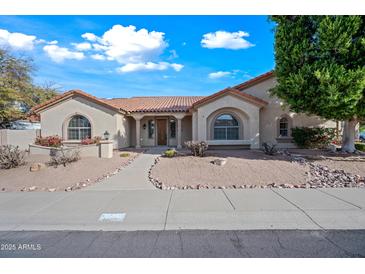 Charming home featuring a terra cotta roof, desert landscaping and covered entry at 10895 E Mission Ln, Scottsdale, AZ 85259