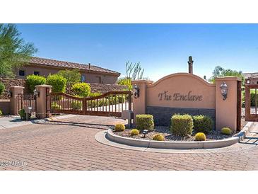 Gated community entrance with desert landscaping, a decorative stone wall, and updated gate lighting at 13044 N Northstar Dr, Fountain Hills, AZ 85268