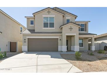 Two-story home featuring a neutral color scheme, two-car garage and a well-manicured yard with desert landscaping at 17745 W Carol Ave, Waddell, AZ 85355