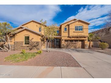 Elegant two-story home featuring a desert landscape, stone accents and a gated entry at 18430 E Ashridge Dr, Queen Creek, AZ 85142