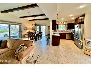 Open-concept living area with tile floors, dark wood beams, and access to outdoor patio at 18753 E Chinle Dr, Rio Verde, AZ 85263