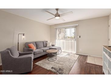 Cozy living room with plush gray seating and a sliding glass door to the outside patio area at 2625 E Indian School Rd # 240, Phoenix, AZ 85016